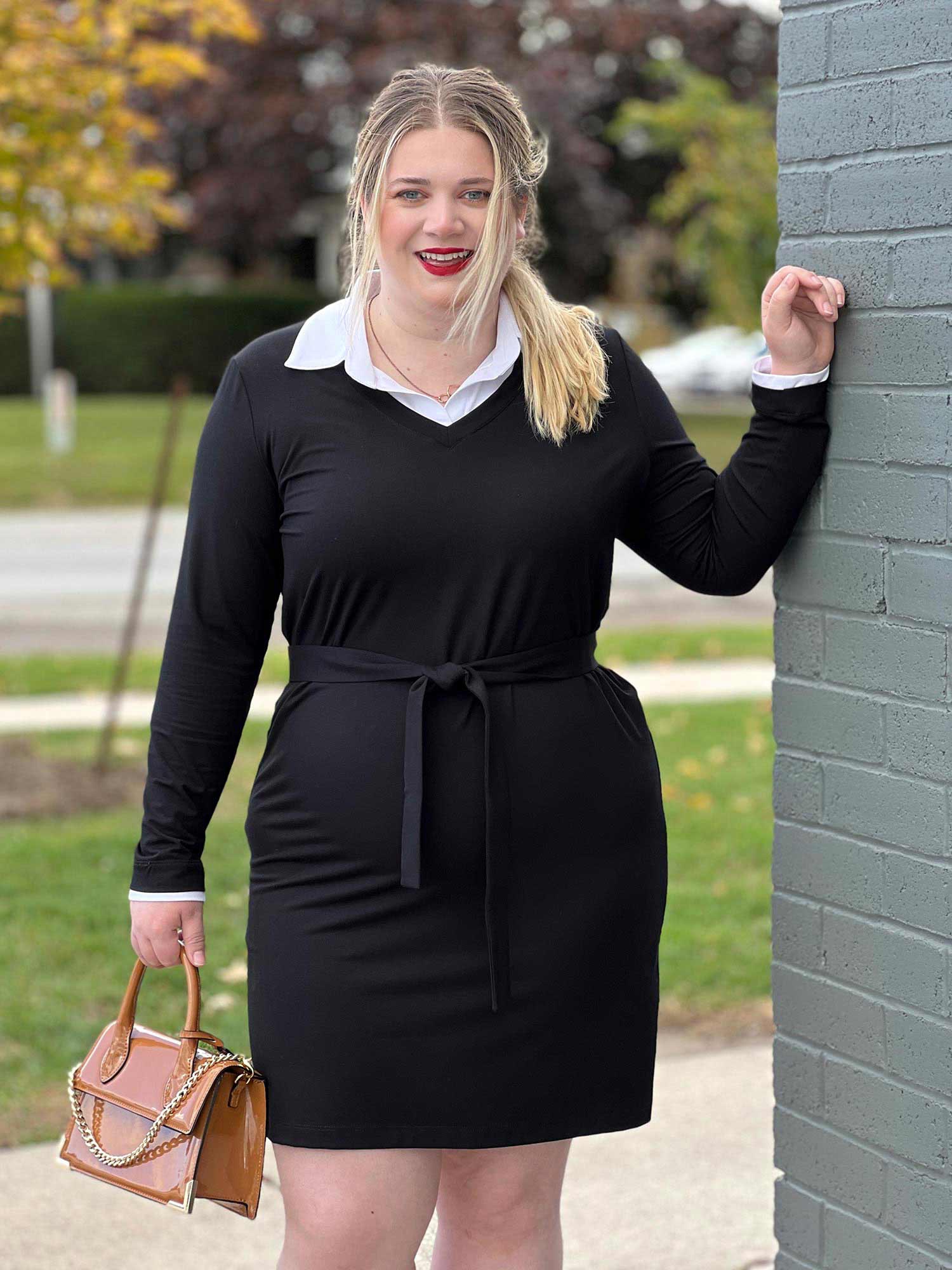 Woman smiling standing next to a brick wall wearing Miik&