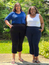 Two women standing next to eachother wearing Miik's Akira tulip hem capri pant in black and navy in plus size.