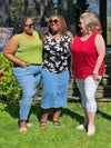 Miik models plus size Kimesha, Erica and Kelly laughing all wearing the same top but in different colours. Kimesha is wearing Miik's Alanis relaxed tank top in green moss, Erica in white lily print while Kelly is wearing in poppy red colour 