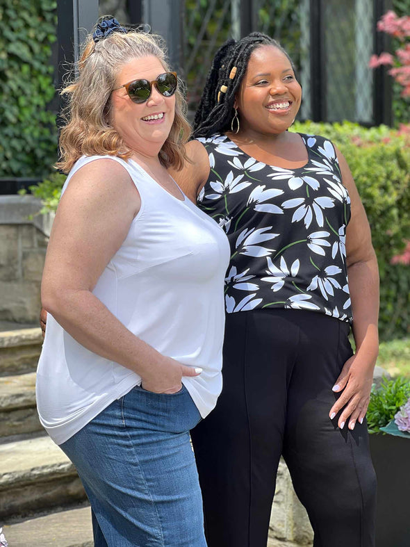 Miik models plus size Kelly and Kimesha smiling while standing sideway wearing both the same top: Miik's Alanis relaxed tank top