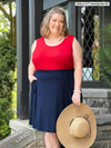 Miik model plus size Kelly (5'7", 3x) smiling wearing Miik's Alanis relaxed tank top in poppy red with a navy skirt 