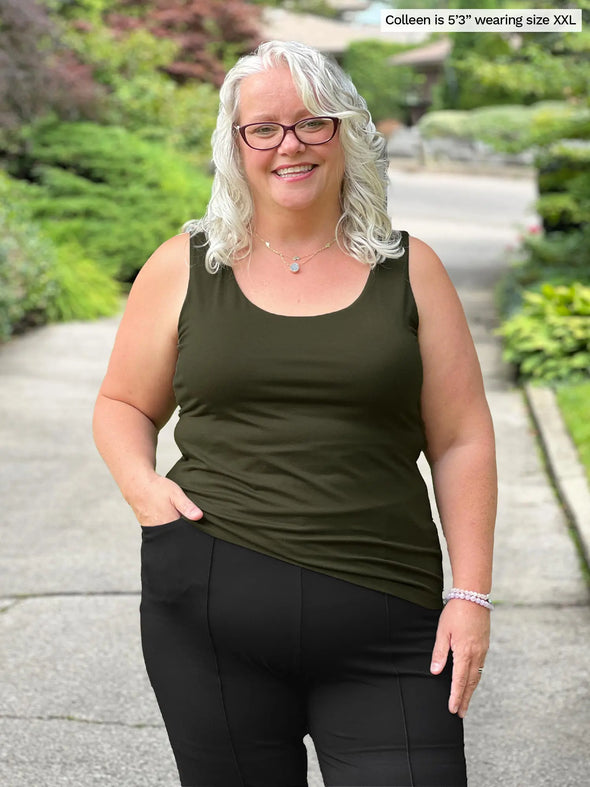 Miik model Colleen (5'3", xxlarge) smiling wearing Miik's Amina reversible tank shelf bra in olive green with a charcoal dress pant 
#color_olive 