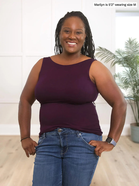 Miik model Marilyn (5'2", medium) smiling wearing Miik's Amina reversible neckline shelf bra tank in port with jeans 
#color_port