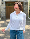 Miik founder Donna (5'6", small) smiling while looking away wearing Miik's Arianna collared shirt in white with jeans #color_white