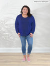 Miik model Marilyn (5'3", large) smiling wearing jeans along with Miik's Aurelia lightweight french terry sweatshirt in marine blue and pink shoes #color_marine-blue