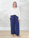 Miik model Kaitlin (5'9", XL/XXL) smiling wearing a marine blue wide leg lounge pant with Miik's Aurelia lightweight french terry sweatshirt in natural #color_natural