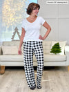 Miik founder Donna (5'6", small) smiling and looking away wearing Miik's Bryce plaid bamboo PJ pant in natural buffalo plaid along with a v-neck tee in white #color_natural-buffalo-plaid