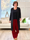 Miik founder Donna (5'6", small) smiling wearing Miik's Bryce plaid bamboo PJ pant in poppy buffalo plaid with a black tank top and a long duster #color_poppy-buffalo-plaid