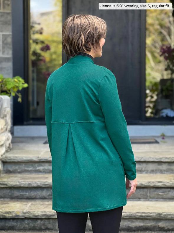 Miik model Jenna (5’9”, small) standing with her back towards the camera showing the back of Miik's Carmen luxe fleece cardigan with pockets in jade melange #color_jade-melange