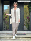 Miik model Jenna (5'9", small) smiling wearing an all mushroom colour outfit with Miik's Carmen luxe fleece cardigan with pockets in oatmeal melange, regular fit #color_oatmeal-melange