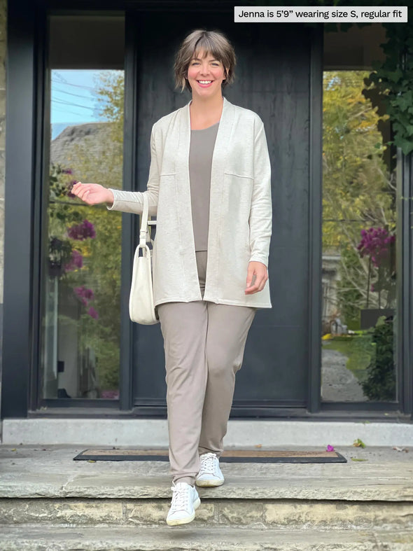 Miik model Jenna (5'9", small) smiling wearing an all mushroom colour outfit with Miik's Carmen luxe fleece cardigan with pockets in oatmeal melange, regular fit #color_oatmeal-melange