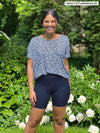 Miik model Meron (5'3", xsmall) smiling wearing a floral blue top with Miik's Chalha high waisted mid thigh biker short in navy