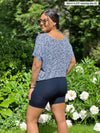 Miik model Meron (5’3”, xsmall) standing with her back towards the camera showing the back of Miik's Chalha high waisted mid thigh biker short in navy