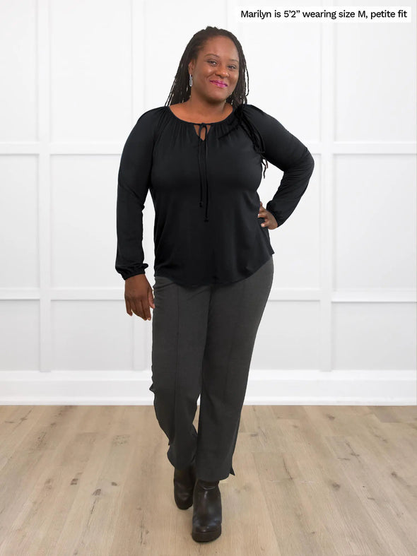 Miik model Marilyn (5'2". medium) smiling wearing a black blouse along with Miik's Christal pintuck pull on ankle pant in charcoal 
#color_charcoal 