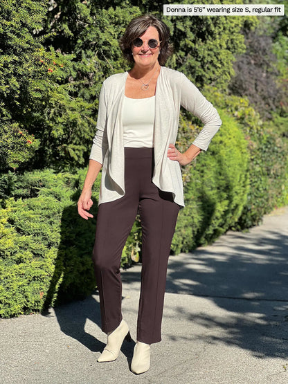 Miik founder Donna (size S, five foot 6) wearing the Christal pull-on pintuck ankle pant in chocolate brown in regular length with an off-white tank and matching cardigan. 