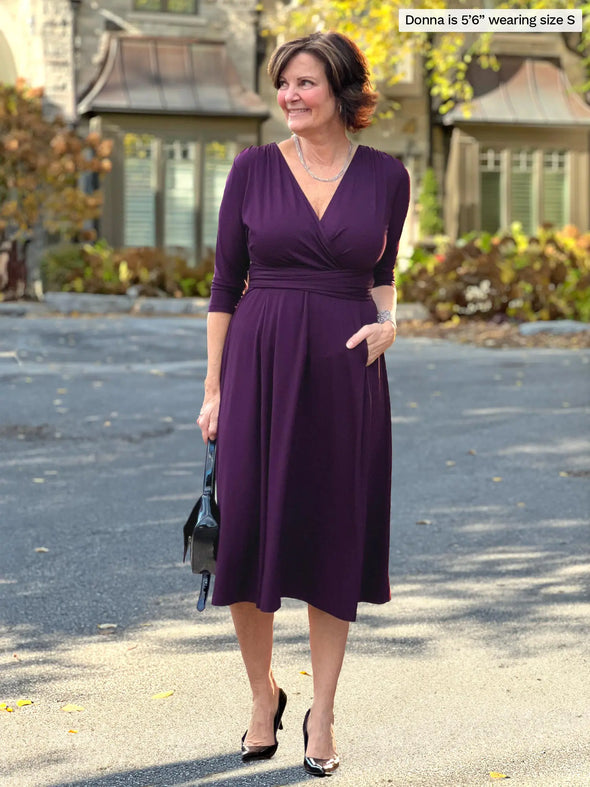 Miik founder Donna (5'6", small) smiling wearing Miik's Claudine tie waist midi dress in port #color_port