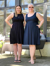 Miik models Christal and Colleen smiling both wearing Miik's Ela reversible pleated sleeveless pocket dress. Christal is wearing in black and Colleen in navy