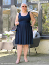 Miik model Colleen (5'3", xxlarge) smiling wearing Miik's Ela reversible pleated sleeveless pocket dress in navy