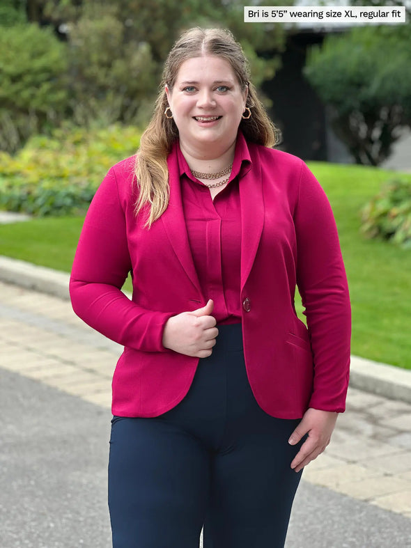 Miik model Bri (5'5", xlarge) smiling wearing Miik's Emily soft blazer in cerise, regular fit, a collared shirt in the same colour and a navy dress pant #color_cerise 