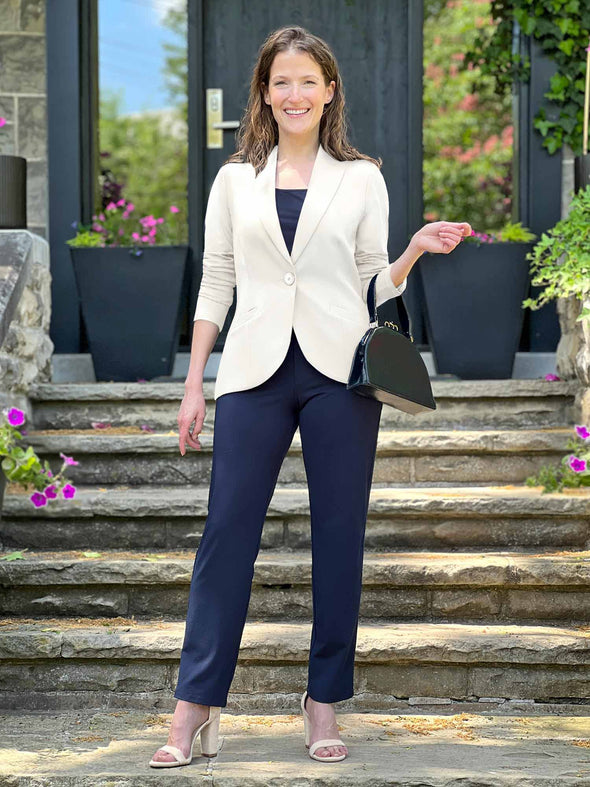 Miik model Lex (5'2", xsmall) smiling wearing a blouse and a pant in navy with Miik's Emily soft blazer in natural