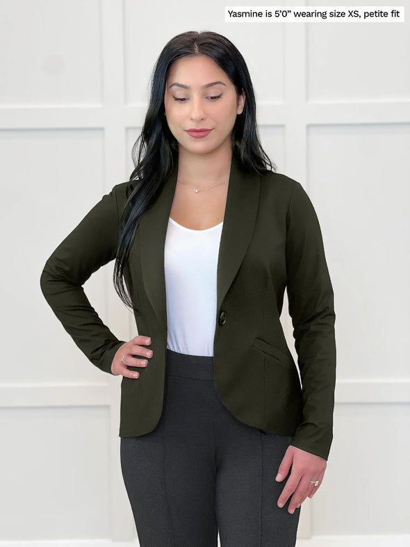 Miik model Yasmine (5'0, xsmall, petite) smiling while looking away wearing Miik's Emily soft blazer in olive, petite fit, with a charcoal dress pant and a white tank #color_olive