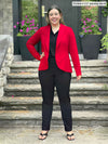 Miik model Christal (5'3, medium) smiling wearing a collared shirt in black with a pant in the same colour and Miik's Emily soft blazer in poppy red 