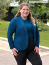 Miik model Bri (5'5", xlarge) smiling wearing Miik's Emily soft blazer in teal, regular fit, with a top in the same colour and a black dress pant #color_teal