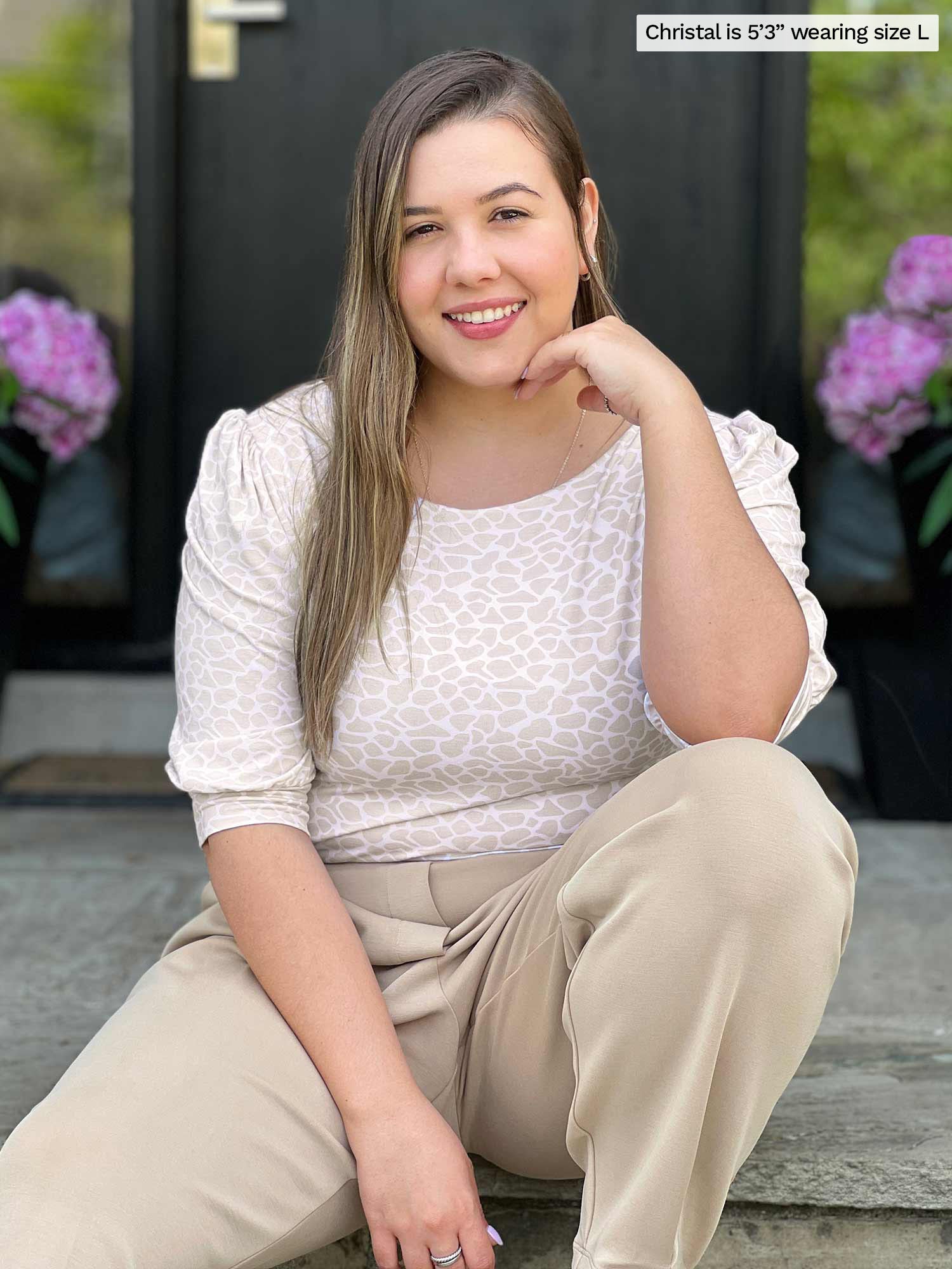 Miik model Christal (five feet three, large) smiling while sitting on a doorway wearing Miik&