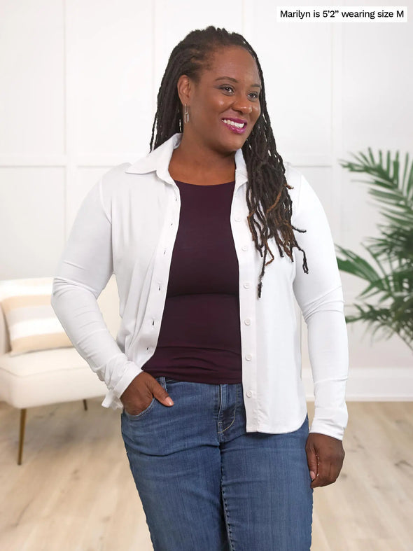 Miik model Marilyn (5'2", medium) smiling and looking away wearing a port tank top with jeans and Miik's Inna long sleeve button up shirt in white oppened
#color_white 