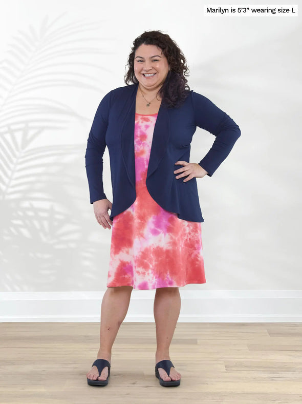 Miik model Marilyn (5'3", large) smiling wearing Miik's Jackie french terry tank dress in coral reef tie dye print with a waterfall cardigan in navy #color_coral-reef