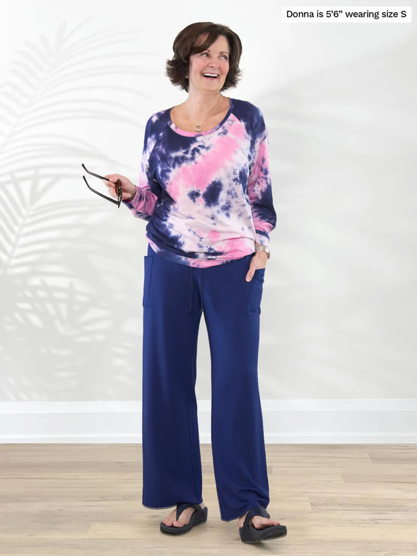 Miik founder Donna (5'6", small) laughing while wearing Miik's Kimber french terry wide leg lounge pant in marine blue along with a tie dye sweatshirt #color_marine-blue 