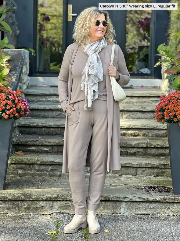 Miik model Carolyn (5'10", large) smiling and looking away wearing Miik's Larissa duster cardigan with pockets in mushroom melange, regular fit, along with a jogger and tee in the same colour #color_mushroom-melange 