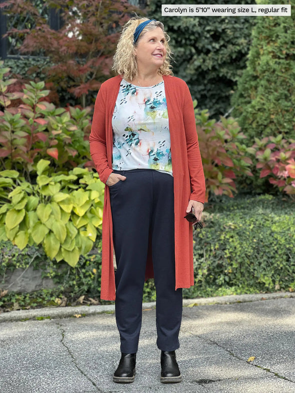 Miik model Carolyn (5'10", large) wearing Miik's Larissa duster cardigan with pockets in paprika melange, regula fit, with a printed tee and a navy jogger #color_paprika-melange 