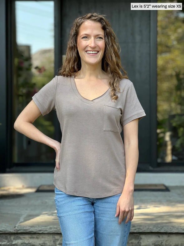 Miik model Lex (5'2", xsmall) smiling wearing Miik's Lex v-neck pocket tee in mushroom melange with jeans 
#color_mushroom-melange