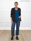 Miik model Meron (5'3", xsmall) smiling wearing a capri jeans, Miik's Lex v-neck pocket tee in teal and a soft blazer in black 
#color_teal 