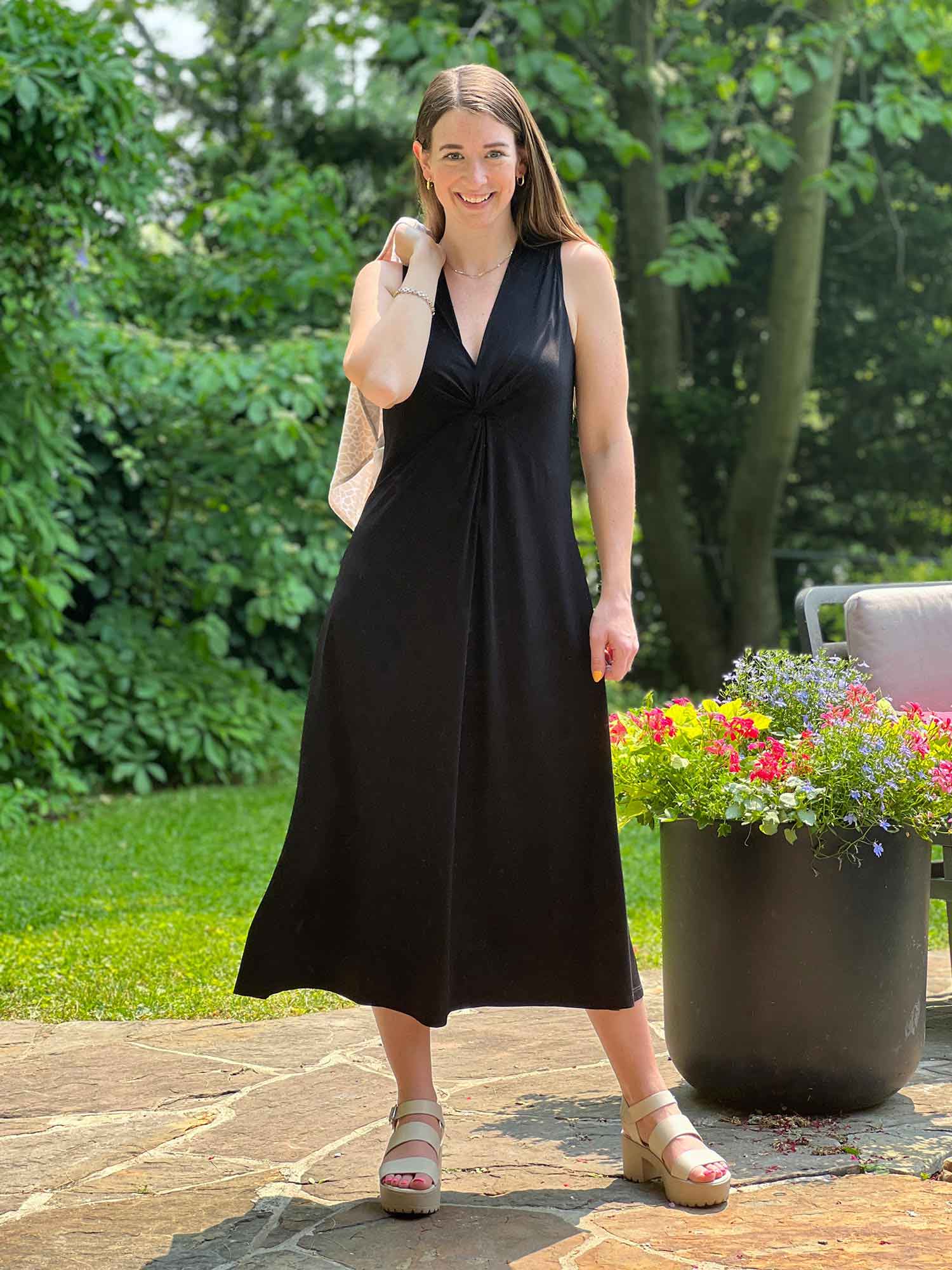 Miik model Johanna (five feet six, xsmall) standing on a backyard smiling wearing Miik&