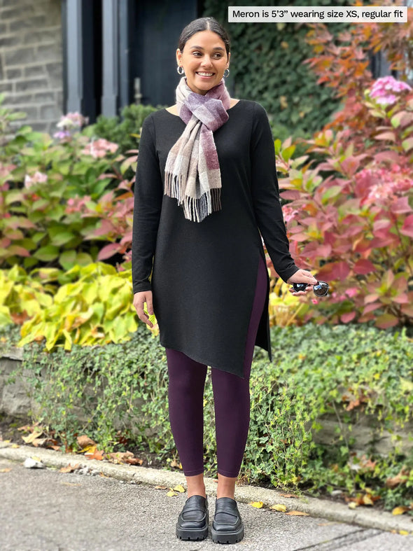 Miik model Meron (5'3", xsmall) smiling wearing Miik's Lisa2 high waisted legging in port, regular fit, with a charcoal tunic and a scarf #color_port 