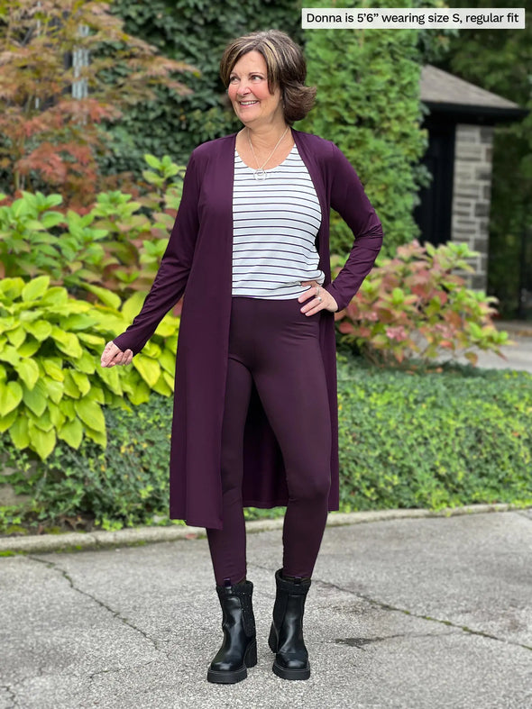 Miik founder Donna (5'6", small) smiling wearing Miik's Lisa2 high waisted legging in port, regular fit, with a matching colour duster cardigan and a striped tank #color_port