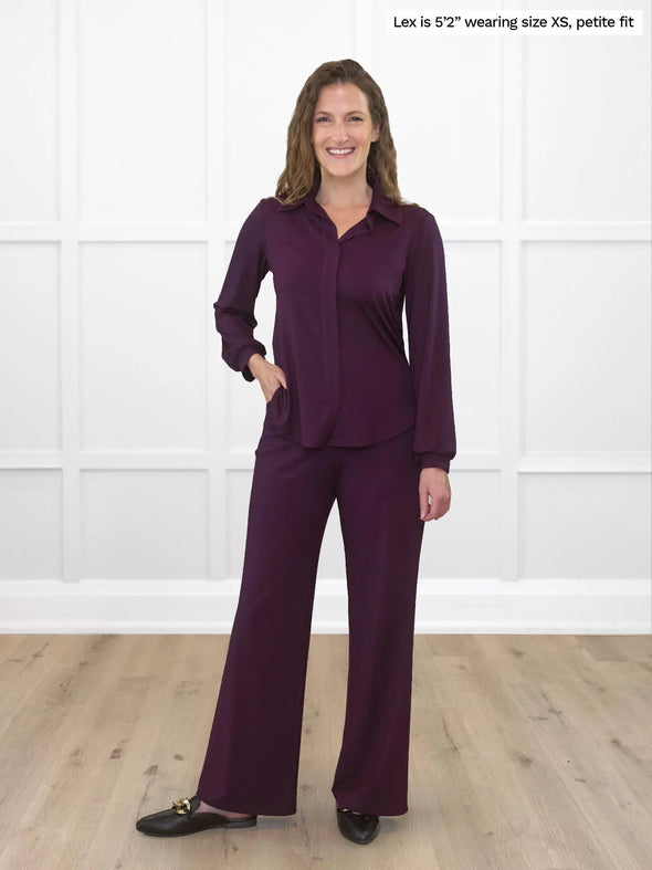 Miik model Lex (5'2", xsmall) smiling wearing Miik's Lucia collared shirt in port, petite fit, along with a high waisted pant in the same colour 
#color_port