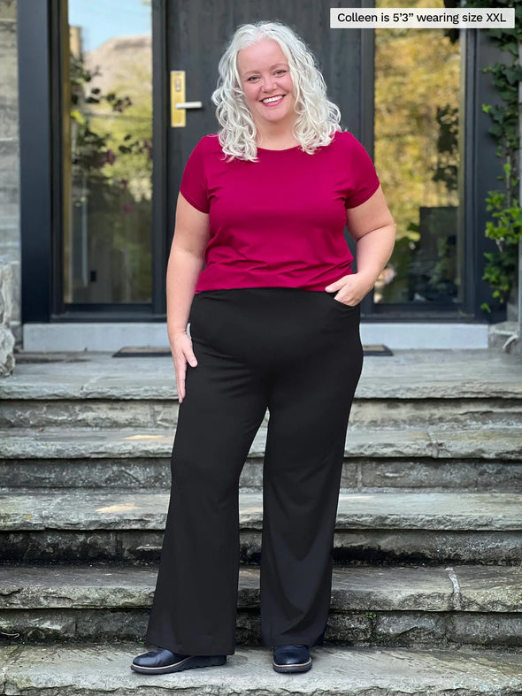 Miik model Colleen (5'3", xxlarge) smiling wearing Miik's Marianna reversible neckline classic tee in cerise with a black pant 
#color_cerise