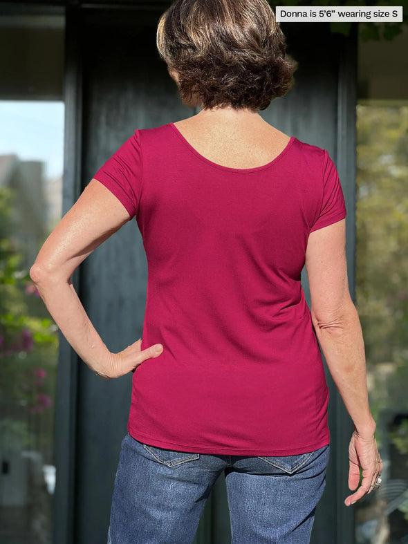 Miik founder Donna (5’6”, small) standing with her back towards the camera showing the back of Miik's Marianna reversible neckline classic tee in cerise and jeans 
#color_cerise 