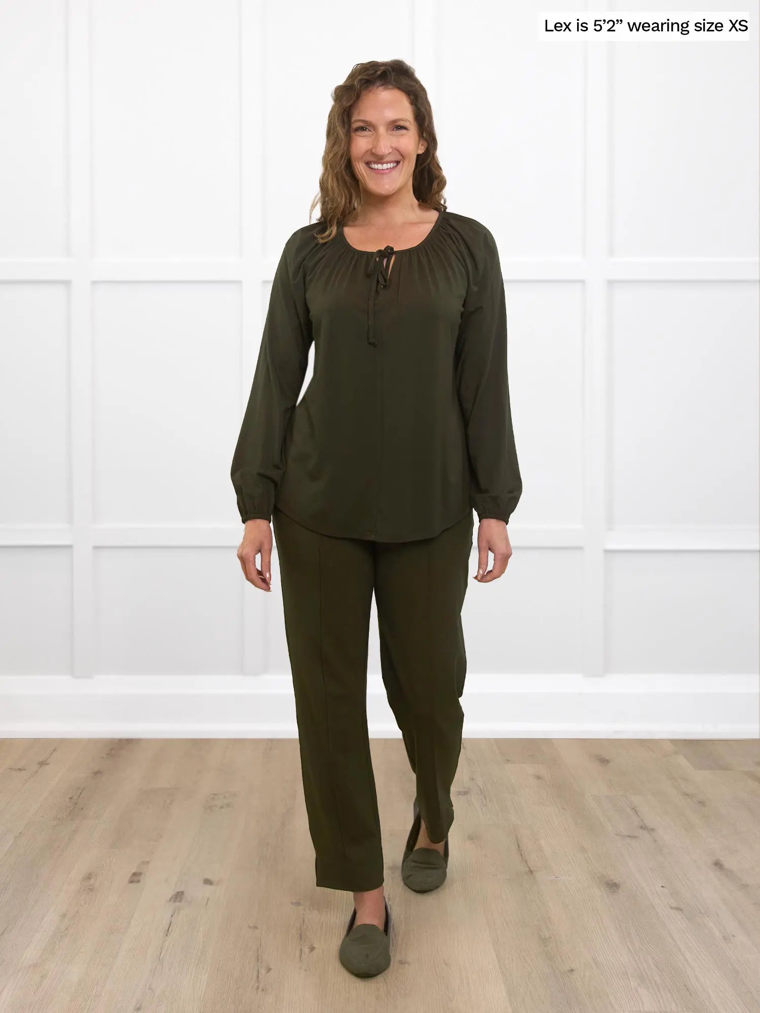 Miik model Lex (size XS) wearing the Mitchel long sleeve bohemian peasant blouse in olive green with matching olive green pants. 