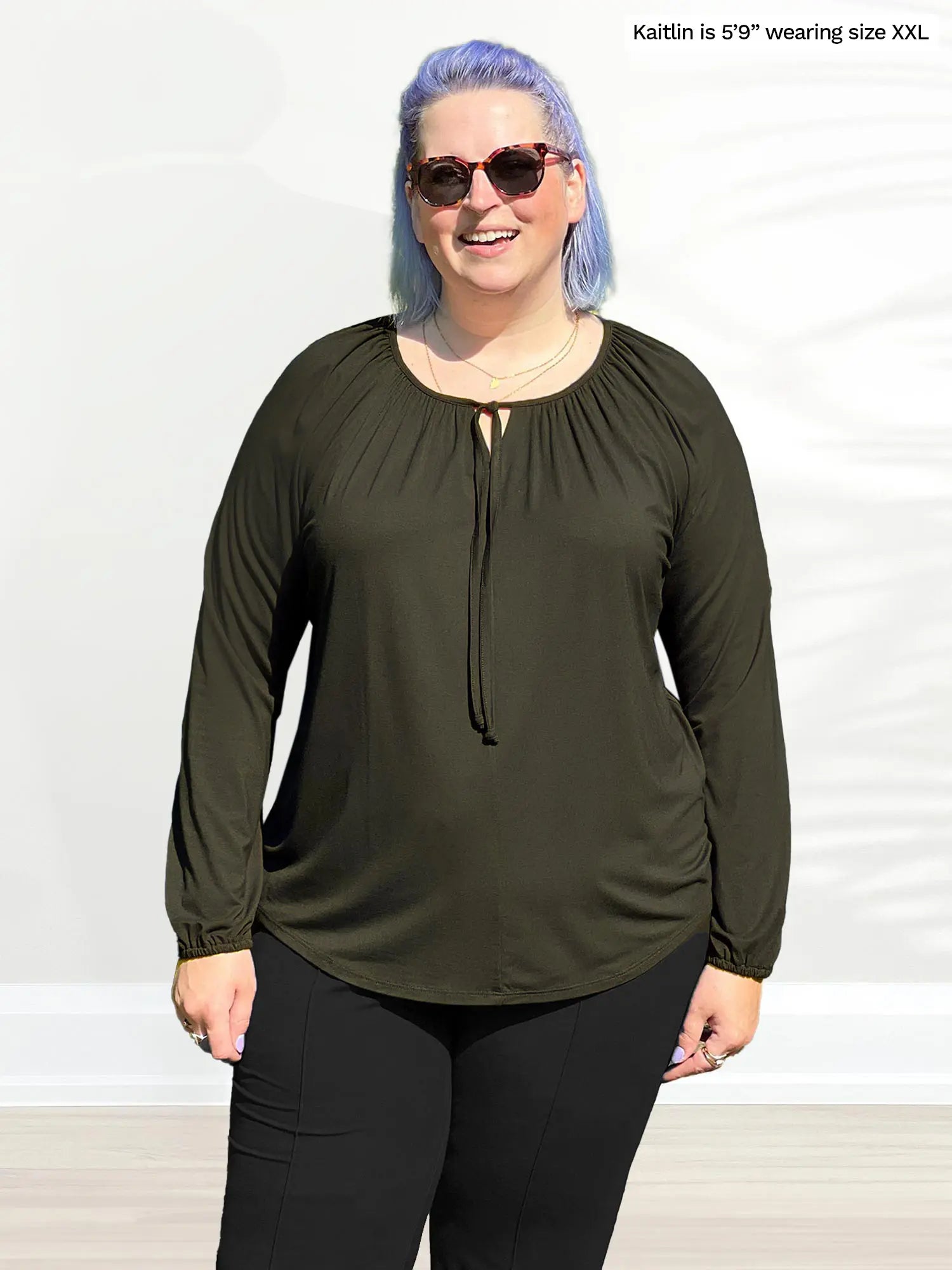 Miik model Kaitlin (size XXL) wearing the Mitchel gathered sleeve peasant blouse in olive green with black pants. 