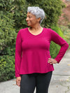 Miik model Keethai (5'5", medium) looking away wearing Miik's Pippa reversible neckline long sleeve top in cerise with a charcoal legging #color_cerise 