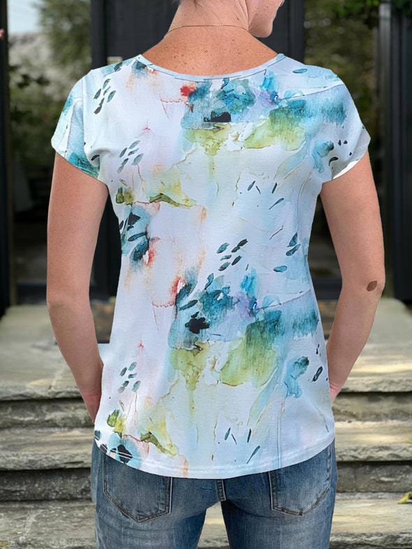 Woman showing the back of the Rio dolman t-shirt in the water lily print. #color_water-lily