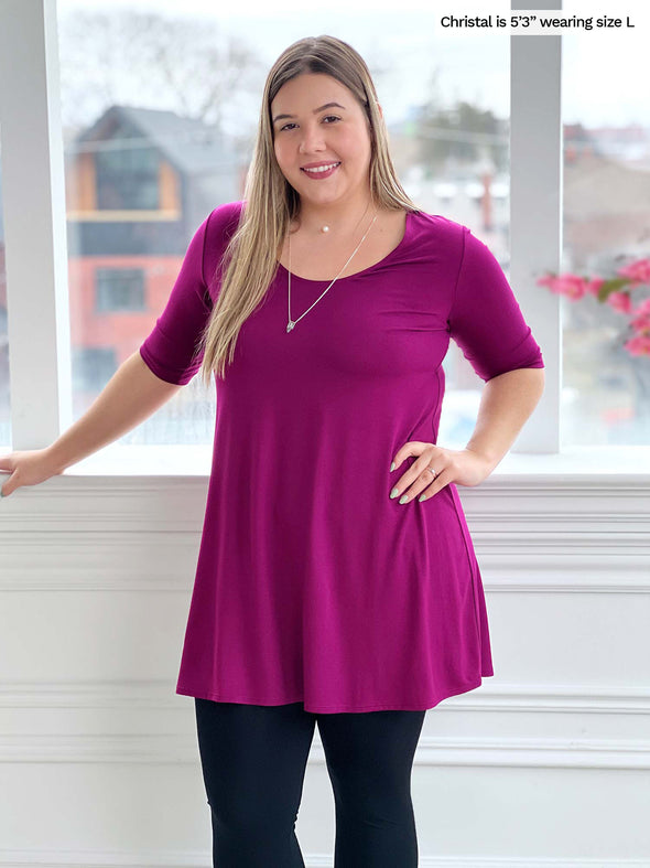 Woman standing wearing Miik's Rocelle half-sleeve scoop neck tunic in ruby pink with leggings