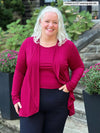 Miik model Colleen (5'3", xxlarge) smiling wearing a navy pant along with Miik's Rory waterfall cardigan in cerise with a tank in the same colour 
#color_cerise 