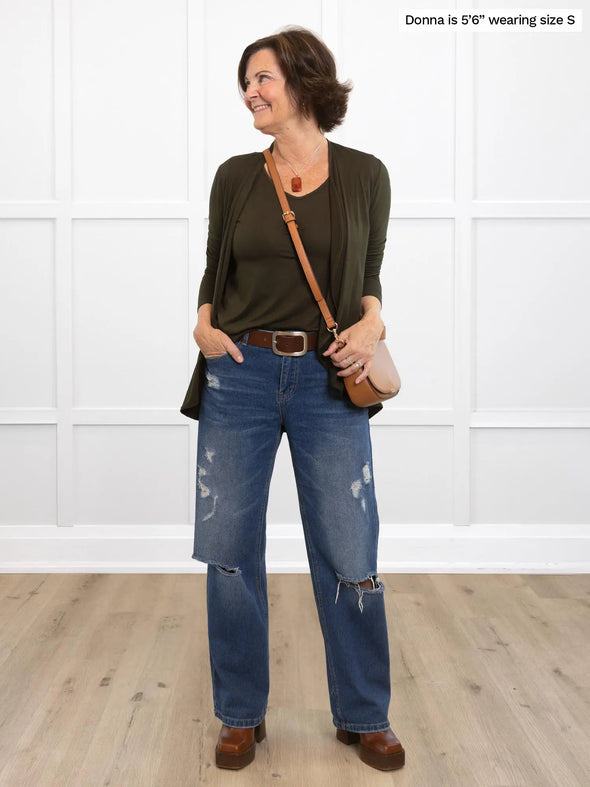 Miik founder Donna (5'6", small) smiling and looking away wearing  Miik's Rory waterfall cardigan in olive with a matching colour tank top with jeans and a crossbody purse 
#color_olive 