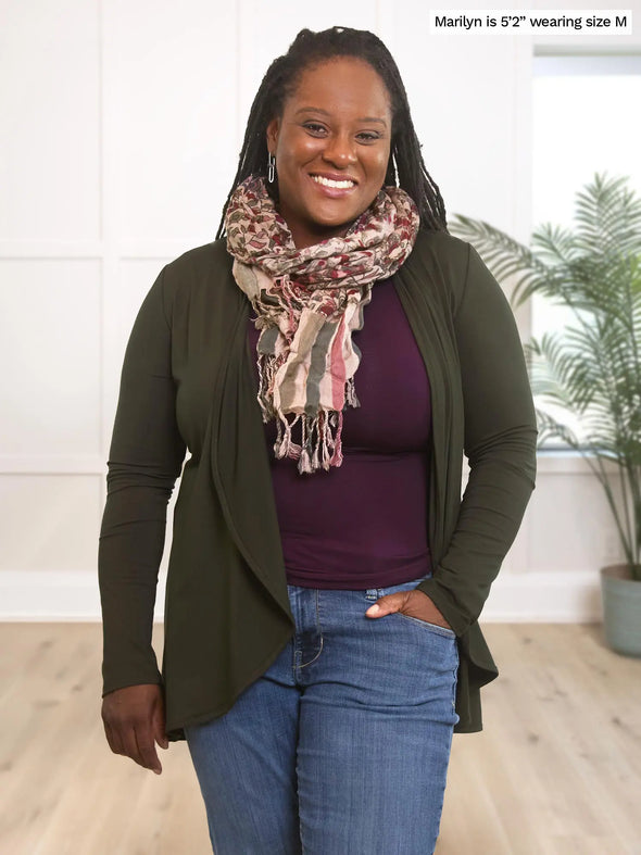 Miik model Marilyn (5'2", medium) smiling wearing Miik's Rory waterfall cardigan in olive with a dark purple tee, a matching printed scarf and jeans 
#color_olive