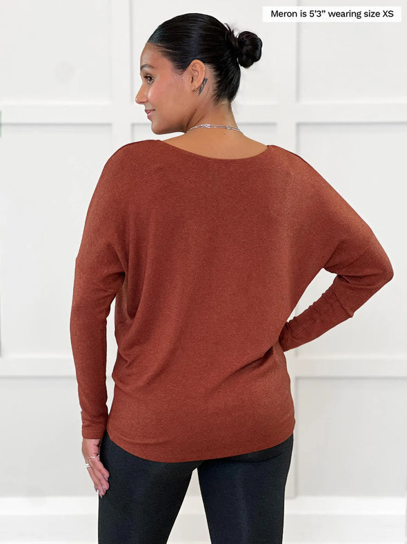 Miik model Meron (5’3”, xsmall) standing with her back towards the camera showing the back of Miik's Rosalie long sleeve dolman sweater in chestnut
#color_chestnut